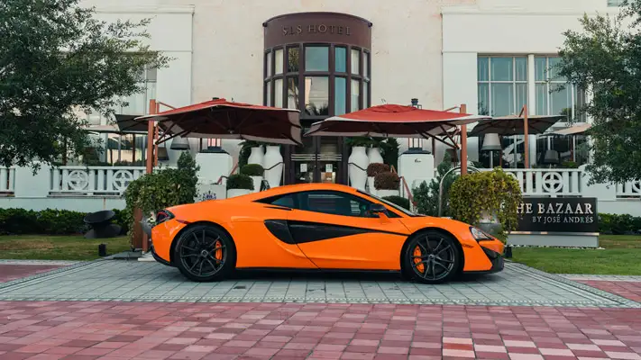 Orange McLaren 570s rental side view mph club