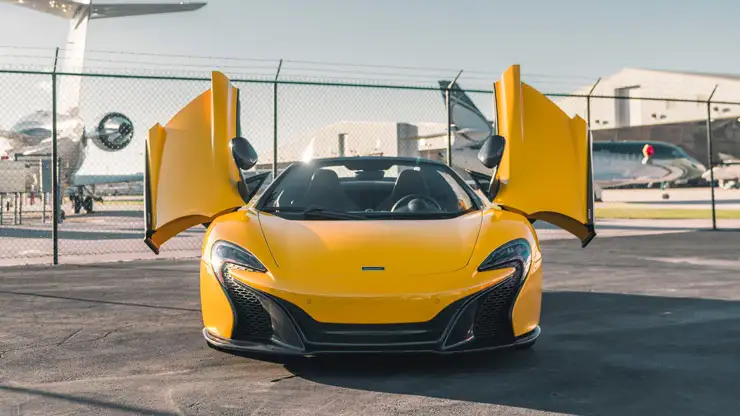 Yellow McLaren 650s Spider rental front view mph club