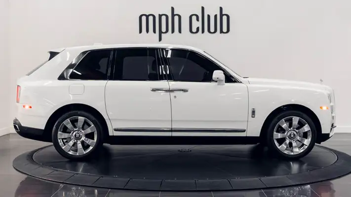 White exterior with orange interior Rolls Royce Cullinan rental side view mph club